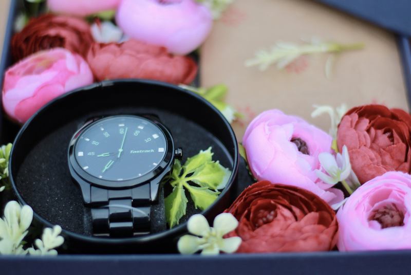 Personalised gift box with a men's wristwatch among pink and red peonies