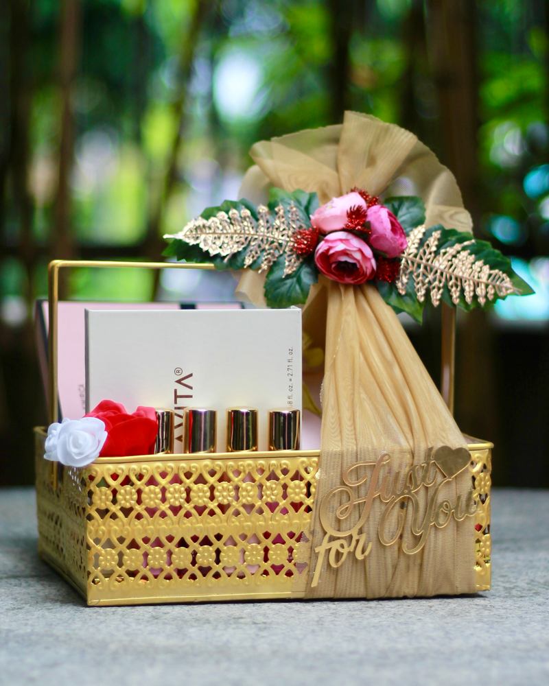Personalised gift hamper by The Pastelist: a gold lattice basket with a gift box, lipsticks and a tulle bow with pink roses